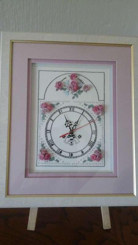 JUST LIKE GRANNY WOULD HAVE MADE AN UNUSUAL HAND EMBROIDERED CLOCK IN A WOODEN FRAME WITH GLASS