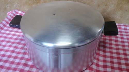 A FABULOUS LARGE ALUMINIUM POT WITH TWO HANDLES. PITY THE HANDLE IS MISSING ON THE LID