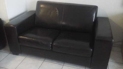 A COMFORTABLE BROWN FAUX LEATHER BOXED SHAPED TWO  SEATER COUCH. BACK IS ROUNDED FOR COMFORT