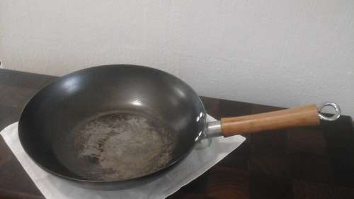 AN AWESOME LARGE WOK. STEEL WITH A WOODEN  HANDLE. CAN PREPARE FOOD FOR A FEW MOUTHS