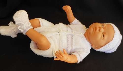 Newborn baby girl doll in new outfit knitted for her.