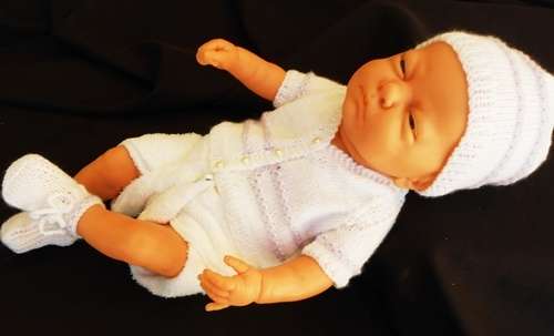 Newborn baby girl doll in new outfit knitted for her.