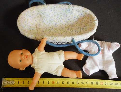 small soft bodied Simba doll in plastic carry basket