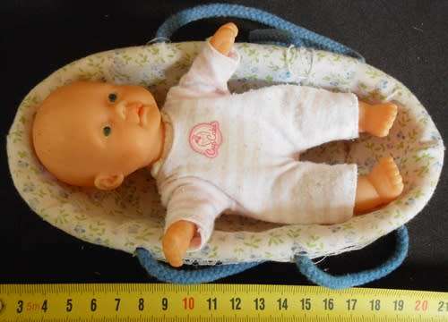 small soft bodied Simba doll in plastic carry basket