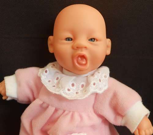 Small soft bodied doll Gi Go Toys with yawning face.