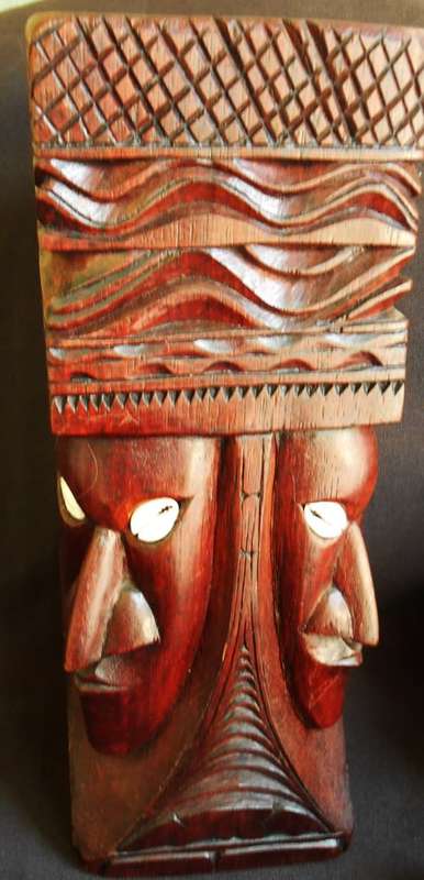 well made wooden statue in hard wood carved with heads with cowrie shell eyes