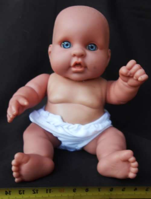 Chubby Baby Girl Doll anatomically correct in pink knitted dress.