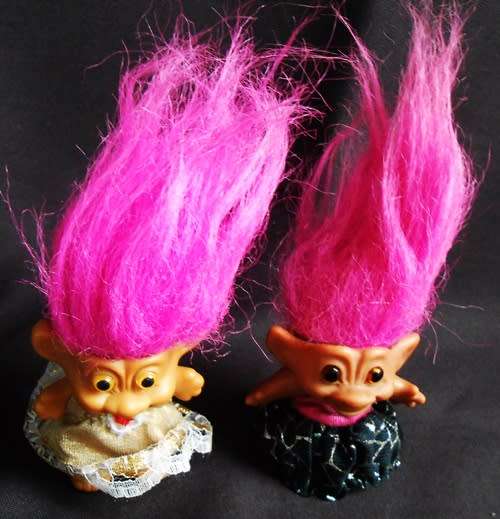Two small Collectable Troll dolls with pink hair dressed in party dresses