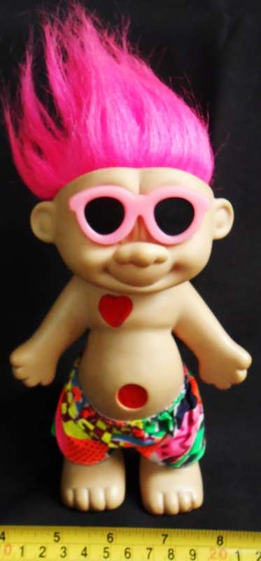 Collectable Troll doll with pink hair and a loving heart in a beach outfit