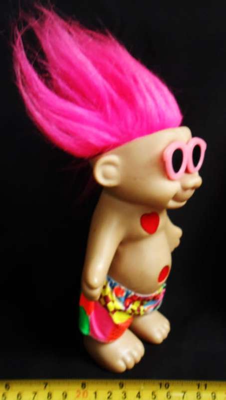Collectable Troll doll with pink hair and a loving heart in a beach outfit