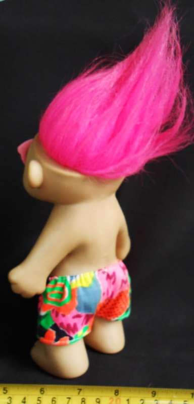 Collectable Troll doll with pink hair and a loving heart in a beach outfit