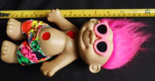 Collectable Troll doll with pink hair and a loving heart in a beach outfit