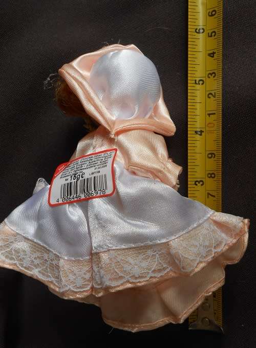 collectable small porcelain doll, Heidel, bearing flowers and a gift