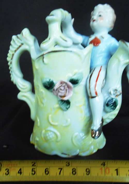 Porcelain vase in shape of watering can with figure and decoration.Retro kitsch