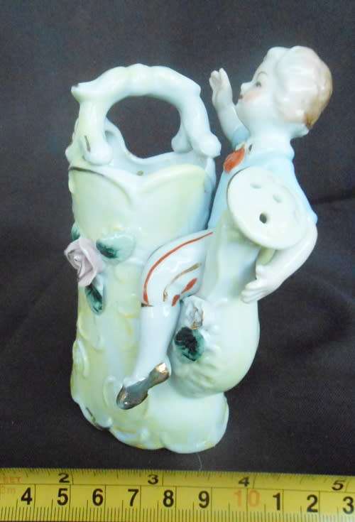 Porcelain vase in shape of watering can with figure and decoration.Retro kitsch