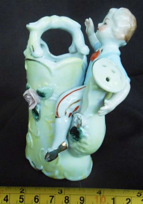 Porcelain vase in shape of watering can with figure and decoration.Retro kitsch