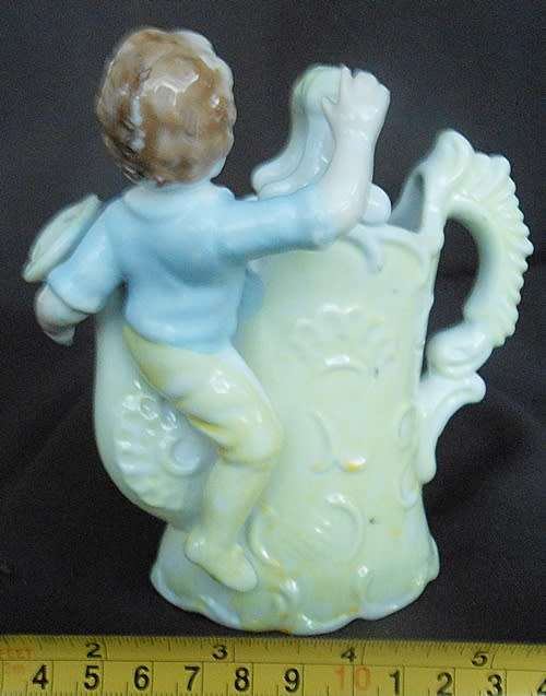 Porcelain vase in shape of watering can with figure and decoration.Retro kitsch