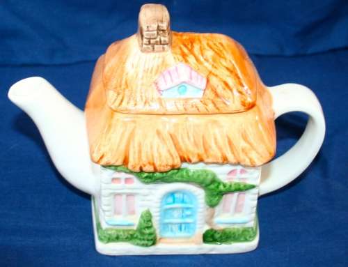 A STUNNING DETAILED PORCELAIN TEA POT IN THE SHAP OF A HOUSE WITH BEAUTIFUL COLORS