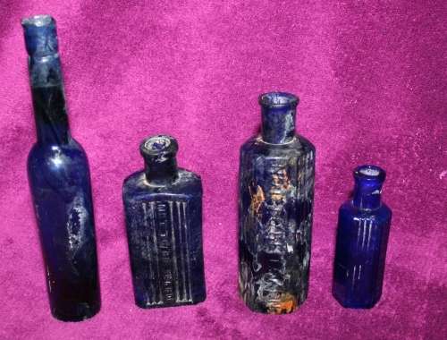 FOUR MAGNIFICENT ANTIQUE BLUE GLASS BOTTLES 3 ARE EMBOSSED NOT TO BE TAKEN!!
