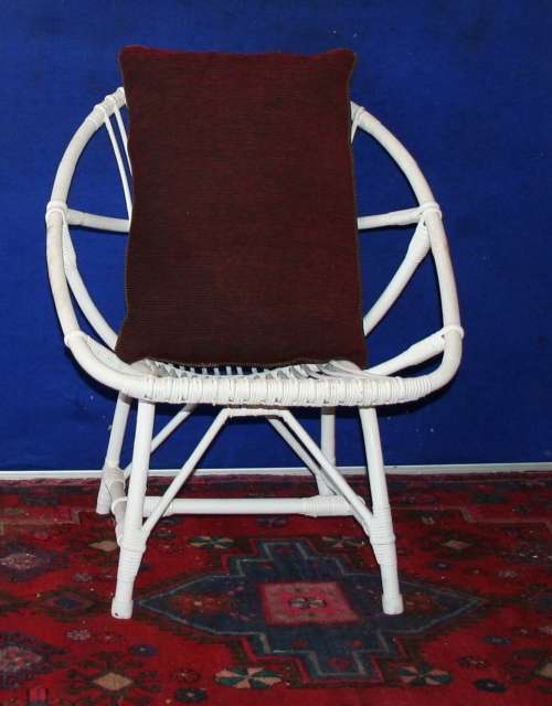 A STUNNING OVAL CRISP WHITE CANE CHAIR WITH A LARGE COMFORTABLE MAROON CUSHION