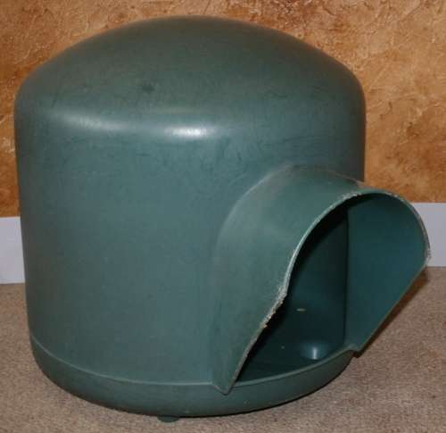 A HARD GREEN PLASTIC DOG KENNEL -
