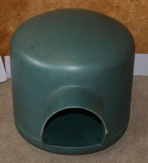 A HARD GREEN PLASTIC DOG KENNEL -