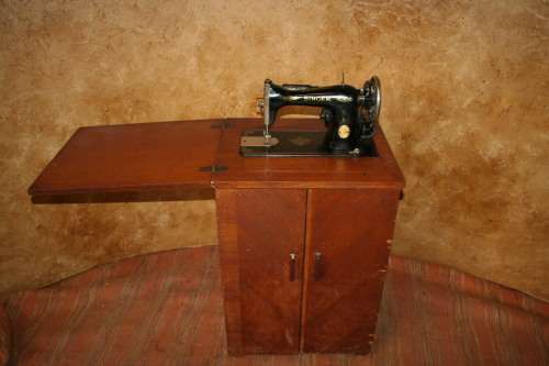 AN INCREDIBLE ANTIQUE  SINGER "TREADLE" SEWING MACHINE IN WONDERFUL CONDITION IN THE ORIGINAL CUPBOA