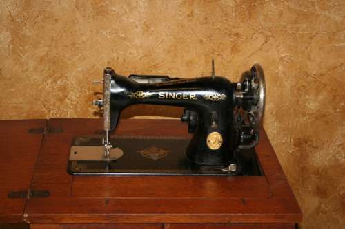 AN INCREDIBLE ANTIQUE  SINGER "TREADLE" SEWING MACHINE IN WONDERFUL CONDITION IN THE ORIGINAL CUPBOA