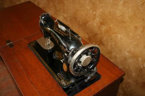 AN INCREDIBLE ANTIQUE  SINGER "TREADLE" SEWING MACHINE IN WONDERFUL CONDITION IN THE ORIGINAL CUPBOA
