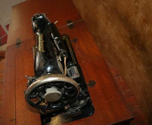 AN INCREDIBLE ANTIQUE  SINGER "TREADLE" SEWING MACHINE IN WONDERFUL CONDITION IN THE ORIGINAL CUPBOA