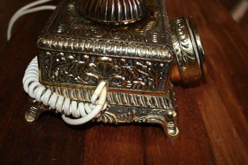 AN EXQUISITE VINTAGE ROTARY DIAL TELEPHONE WITH WHITE BAKELITE HANDLE AND EMBOSSED DETAILING