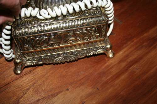 AN EXQUISITE VINTAGE ROTARY DIAL TELEPHONE WITH WHITE BAKELITE HANDLE AND EMBOSSED DETAILING