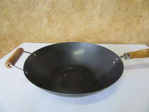 Large vintage steel wok with wooden handle. This is a very large and heavy duty wok.