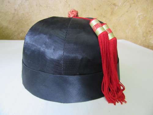 A GORGEOUS BLACK HAT WITH A RED TOSSEL FOR THE HAT COLLECTORS OR FOR THE NEXT HAT PARTY