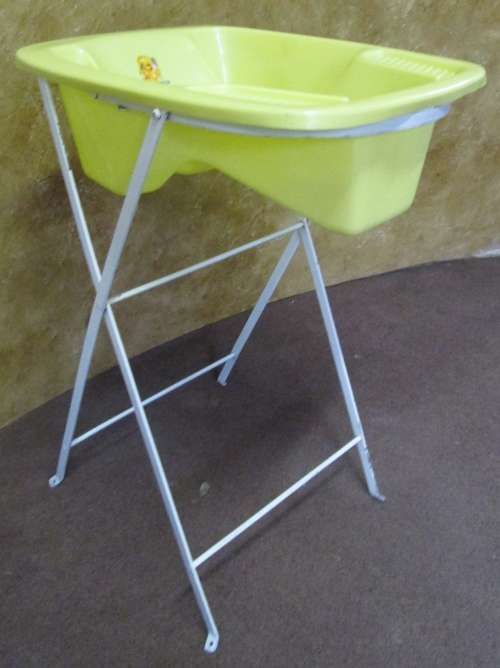 A CUTE VINTAGE BABY BATH ON A TALL METAL FOLD UP STAND