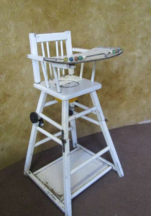 A FANTASTIC VINTAGE BABY HIGH CHAIR WITH A POTTY WHOLE AND IT FOLDS DOWN ON WHEELS PLEASE SEE PICTUR