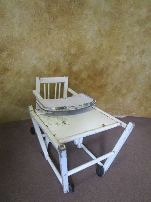 A FANTASTIC VINTAGE BABY HIGH CHAIR WITH A POTTY WHOLE AND IT FOLDS DOWN ON WHEELS PLEASE SEE PICTUR