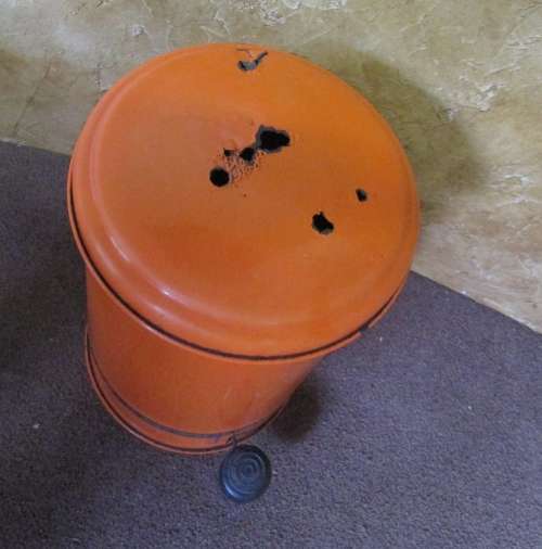 A BRIGHT ORANGE VINTAGE ENAMEL PEDTAL BIN IN WORKING CONDITION