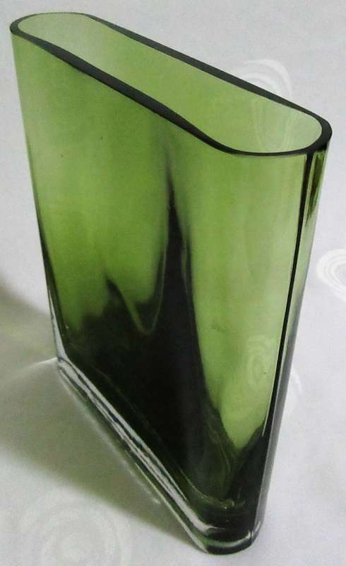 A heavy decorative flower Vase. It's made of an emerald green glass in a modern rectangular shape