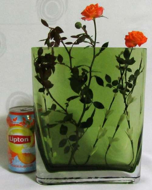 A heavy decorative flower Vase. It's made of an emerald green glass in a modern rectangular shape