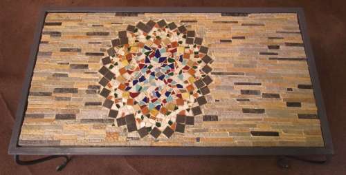 A GORGEOUS OUTDOOR TABLE WITH STEEL LEGS AND FRAME WITH A SOLLID MOSAIC TOP