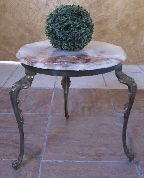 A GORGEOUS AND STYLYS ORNATE BRASS LEG TABLE WITH A STUNNING ONEX TOP