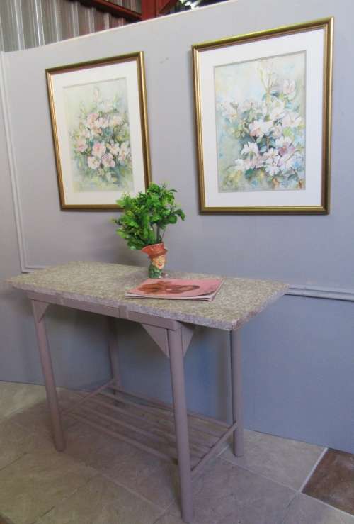 A VERY HANDY TO HAVE A METAL STAND WITH A GRANITE TOP PERFECT FOR CUTTING AND SERVING BY THE BRAAI