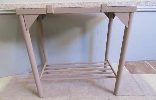 A VERY HANDY TO HAVE A METAL STAND WITH A GRANITE TOP PERFECT FOR CUTTING AND SERVING BY THE BRAAI
