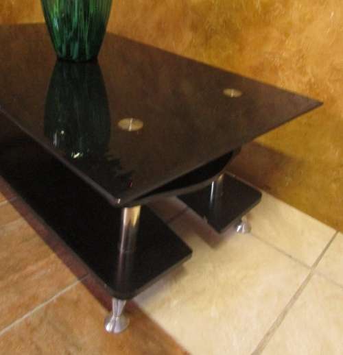 A MODERN STYLE BLACK GLASS AND STAINLESS STEEL COFFEE TABLE