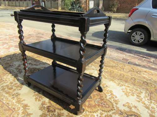 Three-tier tea trolley with barley twist legs and serving tray with a top glass top.