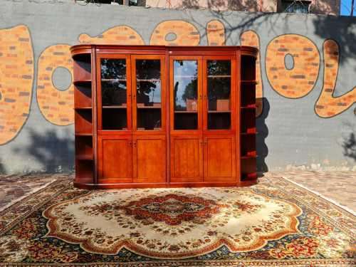 Large display cabinet with four glass doors, side shelves, and four cabinets at the bottom