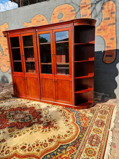 Large display cabinet with four glass doors, side shelves, and four cabinets at the bottom