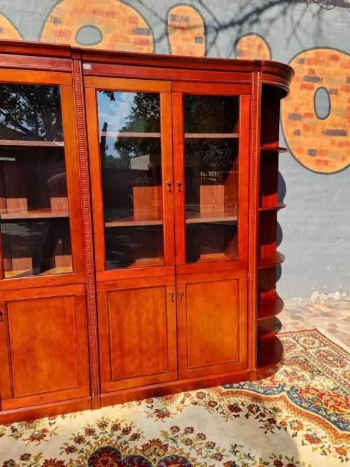 Large display cabinet with four glass doors, side shelves, and four cabinets at the bottom