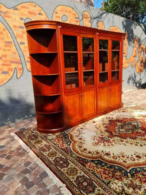 Large display cabinet with four glass doors, side shelves, and four cabinets at the bottom